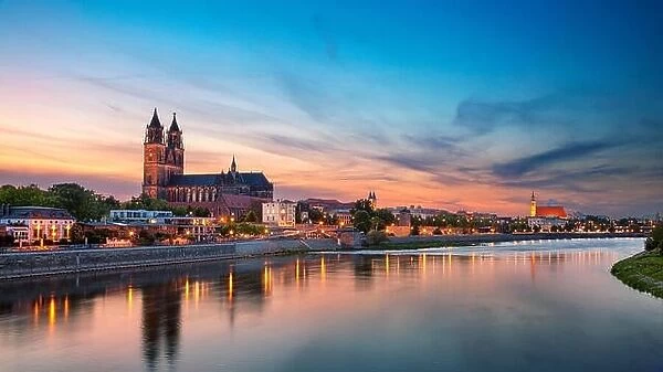 Magdeburg, Germany. Panoramic cityscape image of Magdeburg, Germany with reflection of the city in the Elbe river, during sunset