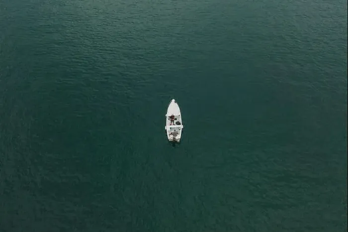Framed Print : Malcesine, Italy - August 7, 2019: Aerial drone shot view of two men in a white boat in lake garda Framed Print : Malcesine, Italy - August 7, 2019: Aerial drone shot view of two men in a white boat in lake garda