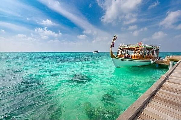 Maldives background with boat and tropical beach scene, blue sea and blue sky with colorful traditional Maldive boat