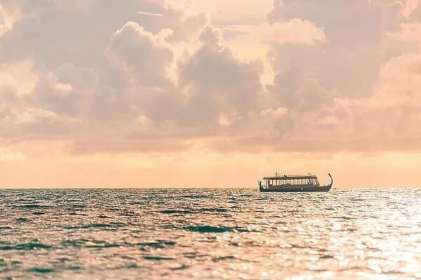 Maldives Sunset cruise with Dhoni boat in Maldives islands. Tropical sea sunset, seascape. People enjoying the sunset and looking for marine life