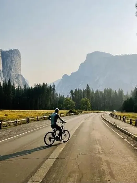 Framed Print : A male rides a bike in the lower Yosemite Valley with beautiful views of Half Dome