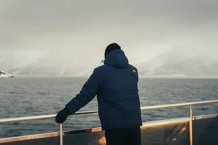 Framed Print : Man in blue coat stood on boat looking at misty Lyngen Alps in Norway winter Framed Print : Man in blue coat stood on boat looking at misty Lyngen Alps in Norway winter