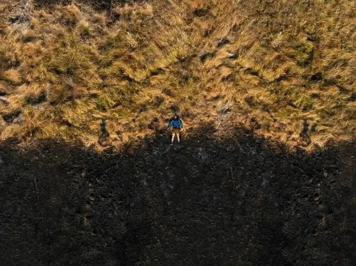 Framed Print : A man in the center of a pasture destroyed by wildfire Framed Print : A man in the center of a pasture destroyed by wildfire