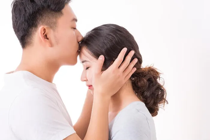 Framed Print : A man kissing his woman's head with love and affection, the woman is enjoying the romance Framed Print : A man kissing his woman's head with love and affection, the woman is enjoying the romance