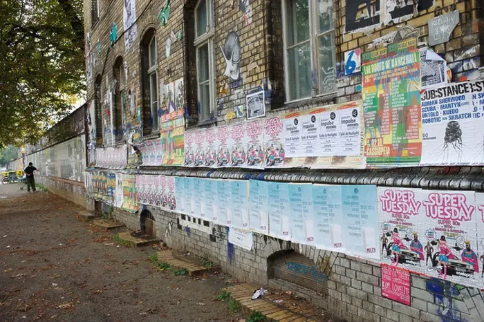 Framed Print : Man putting up posters Framed Print : Man putting up posters