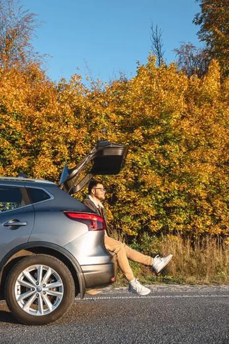 Framed Print : A man sits in the trunk of his car and enjoys the autumn sun as he basks in it Framed Print : A man sits in the trunk of his car and enjoys the autumn sun as he basks in it