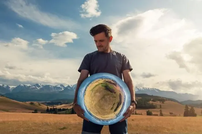 Framed Print : Man standing in in summer Altai mountains in Kurai steppe and holding circle mirror Framed Print : Man standing in in summer Altai mountains in Kurai steppe and holding circle mirror
