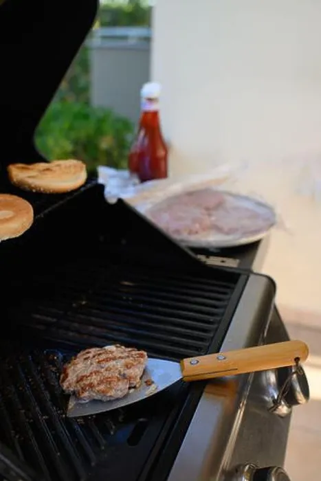 Framed Print : A man is standing near the grill on a terrace, grilling meat Framed Print : A man is standing near the grill on a terrace, grilling meat