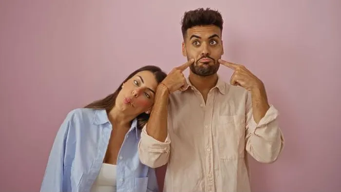 Framed Print : Man and woman making funny faces together against a pink background, showcasing a playful and loving relationship Framed Print : Man and woman making funny faces together against a pink background, showcasing a playful and loving relationship