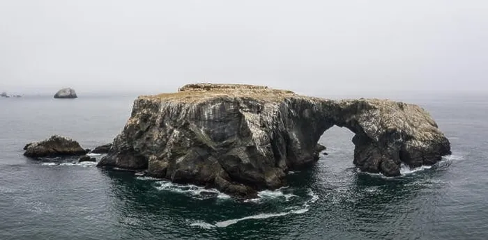 Framed Print : A massive sea stack, formed by the erosive powers of wind and water, rests near the wild, fog-covered coast of northern California Framed Print : A massive sea stack, formed by the erosive powers of wind and water, rests near the wild, fog-covered coast of northern California