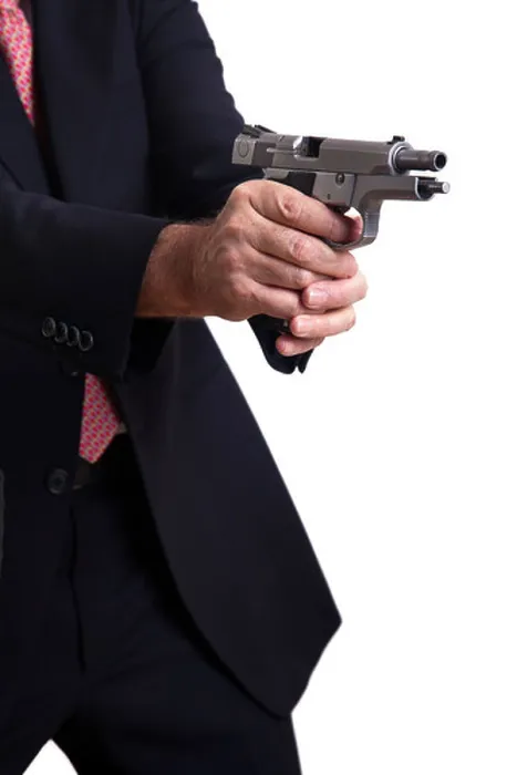 Framed Print : A mature adult man wearing suit holding 9mm gun both hands right in middle firing shot gun's latch in backwards Framed Print : A mature adult man wearing suit holding 9mm gun both hands right in middle firing shot gun's latch in backwards
