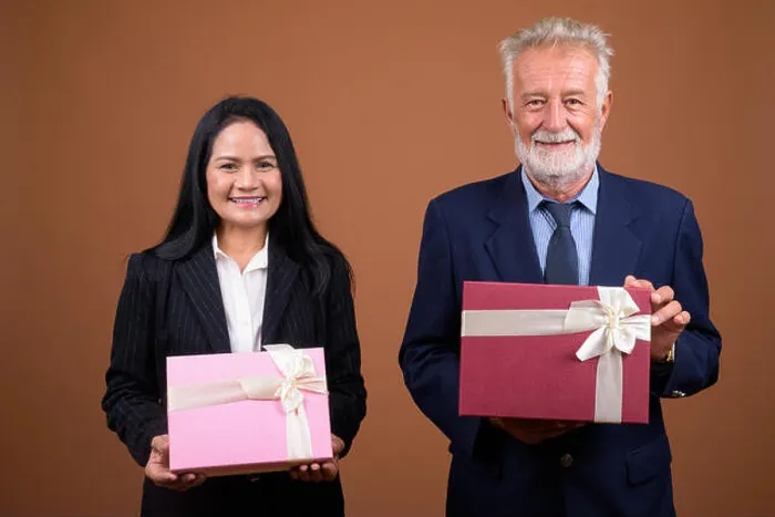 Framed Print : Mature multi-ethnic business couple against brown background Framed Print : Mature multi-ethnic business couple against brown background