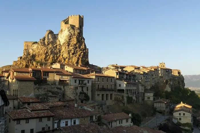 Framed Print : Medieval old town placed on rocky mountain with fortress on top in bright sunlight against blue sky Framed Print : Medieval old town placed on rocky mountain with fortress on top in bright sunlight against blue sky