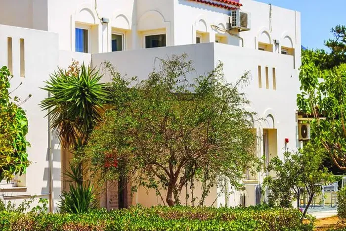 Framed Print : Mediterranean-style building surrounded by green bushes, plants, and tree on sunny day. Crete. Greece Framed Print : Mediterranean-style building surrounded by green bushes, plants, and tree on sunny day. Crete. Greece