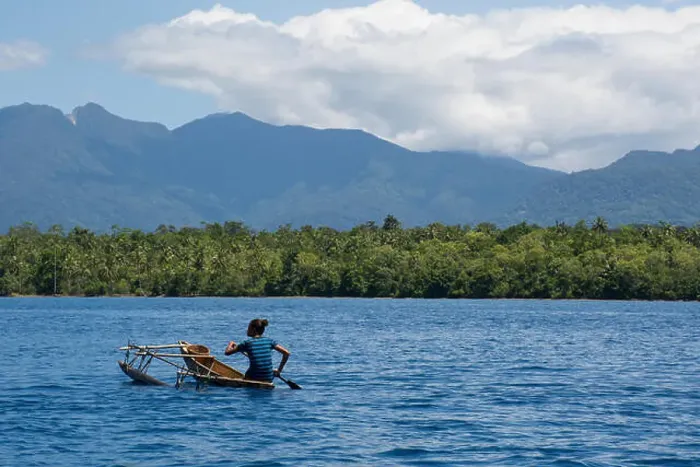 Framed Print : Melanesia, Papua New Guinea, Fergusson Island. Villager in traditional dugout canoe