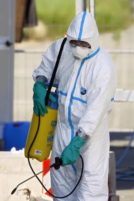 Framed Print : A member of the German Federal Agency for Technical Relief sprays disinfectives at a a poultry farm gate in Warmersdorf