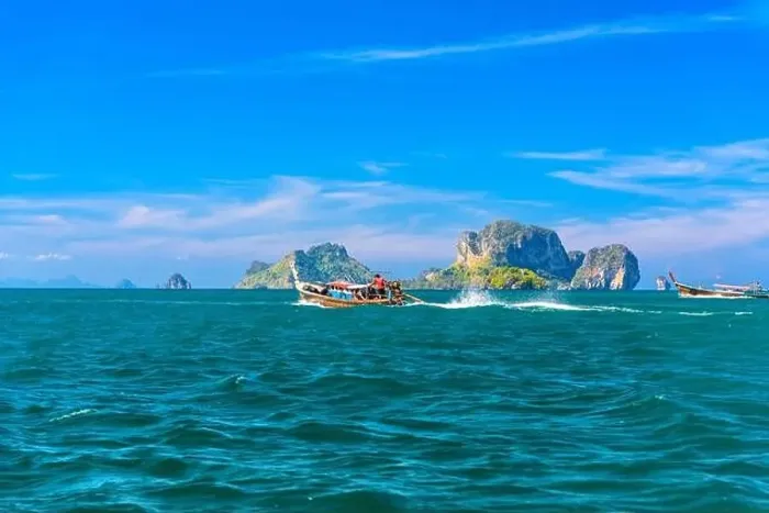 Framed Print : Men in long tail boats with Ko Poda and Ko Kai Chicken Island in the background Framed Print : Men in long tail boats with Ko Poda and Ko Kai Chicken Island in the background