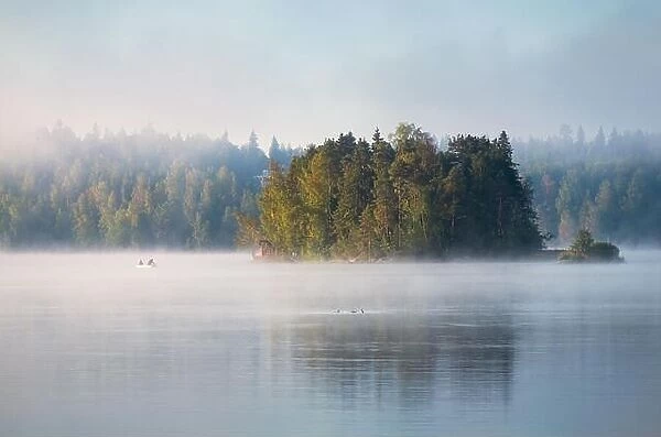 Misty landscape with fisherman and beautiful morning light at mood summer morning in Finland