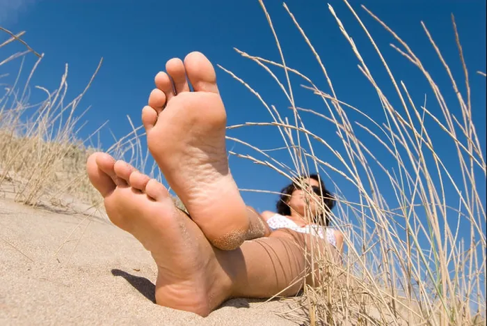 Framed Print : Model Released female feet lying in sand dunes with blue sky and focus on feet Framed Print : Model Released female feet lying in sand dunes with blue sky and focus on feet