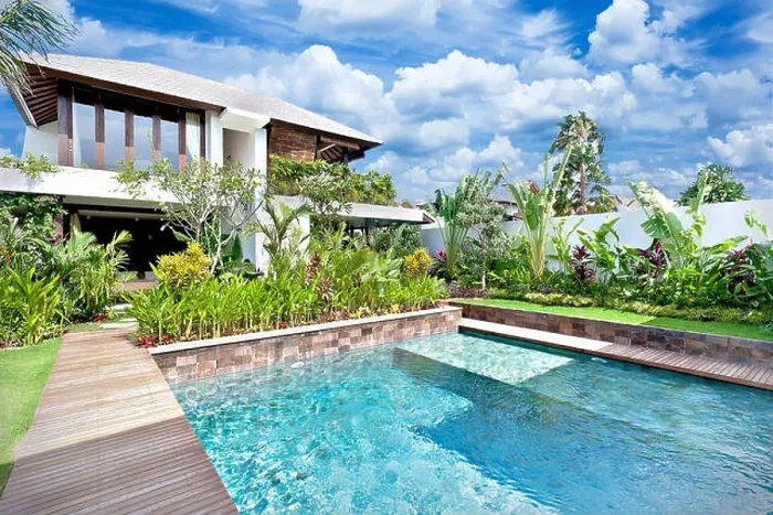 Framed Print : Modern blue water swimming pool in a luxury house with a fancy garden around it