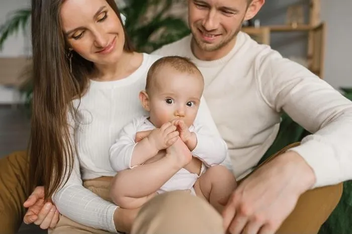 Framed Print : Mom, dad and six-month-old baby son in their arms spend time together in their cozy home Framed Print : Mom, dad and six-month-old baby son in their arms spend time together in their cozy home