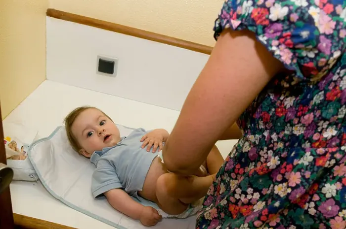 Framed Print : mother changing nappies on a six month year old baby Framed Print : mother changing nappies on a six month year old baby