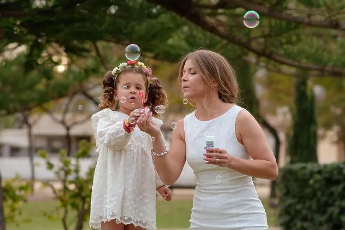 Framed Print : Mother and daughter blow soap bubbles outdoors Framed Print : Mother and daughter blow soap bubbles outdoors