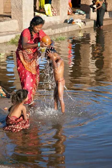 Framed Print : Mother washing her son. Tungabhadra river. Hampi. India