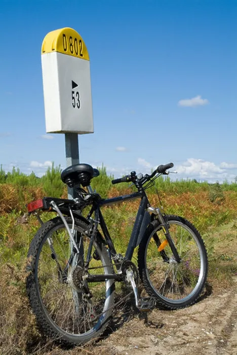 Framed Print : Mountain bike parked against a French milestone D802 country road in Landes Forest, France