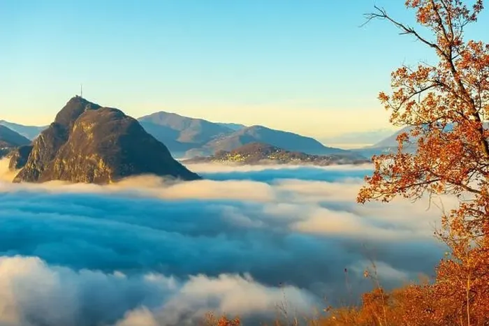 Framed Print : Mountain Peak San Salvatore Above Cloudscape with a Autumn Tree and Sunlight with Clear Sky in Lugano Framed Print : Mountain Peak San Salvatore Above Cloudscape with a Autumn Tree and Sunlight with Clear Sky in Lugano