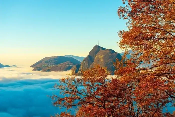 Framed Print : Mountain Peak San Salvatore Above Cloudscape with a Autumn Tree and Sunlight with Clear Sky in Lugano Framed Print : Mountain Peak San Salvatore Above Cloudscape with a Autumn Tree and Sunlight with Clear Sky in Lugano