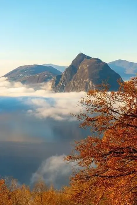Framed Print : Mountain Peak San Salvatore Above Cloudscape with a Autumn Tree and Sunlight with Clear Sky in Lugano Framed Print : Mountain Peak San Salvatore Above Cloudscape with a Autumn Tree and Sunlight with Clear Sky in Lugano