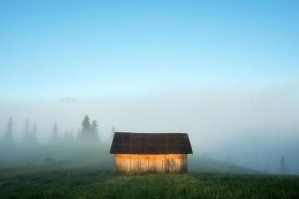 Mountain valley during sunrise. Alone house on foggy meadow. Located place: Carpathians, Ukraine, Europe
