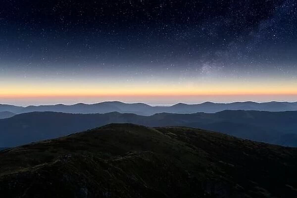 Mountains range against the backdrop of an incredible starry sky. Amazing night landscape with Milky Way. Tourism concept