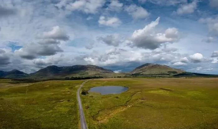 Framed Print : Narrow country road leads into the wild landscape of the Connemara National Park in western Ireland Framed Print : Narrow country road leads into the wild landscape of the Connemara National Park in western Ireland