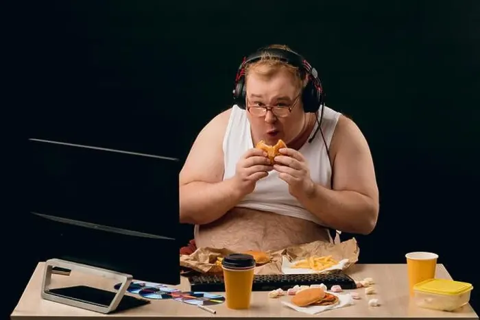 Framed Print : nerd having breakfast while browsing the net, overweight guy breaking the diet. close up portrait Framed Print : nerd having breakfast while browsing the net, overweight guy breaking the diet. close up portrait