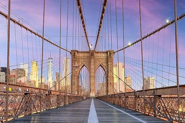 New York, New York on the Brooklyn Bridge Promenade facing Manhattan's skyline at dawn