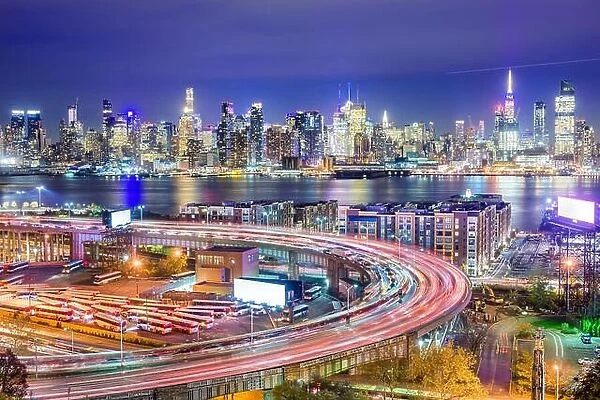 New York, New York, USA cityscape and highways from across the Hudson River at night