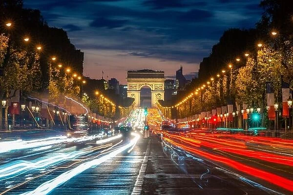 Night scence illuminations traffic street of the Impressive Arc de Triomphe Paris along the famous tree lined Avenue des Champs-Elysees in Paris, Fran