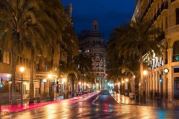 Night street view in Valencia downtown, Spain. Palm Trees in Spanish City of Valencia