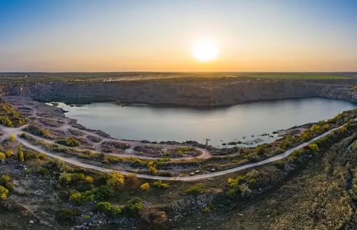 Framed Print : Old flooded stone quarry with large stones in the evening warm bright light covered with small dry plants in Framed Print : Old flooded stone quarry with large stones in the evening warm bright light covered with small dry plants in