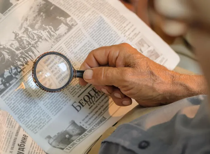Framed Print : Old man reading newspapers with loupe, old repaired fixed magnifying glass Framed Print : Old man reading newspapers with loupe, old repaired fixed magnifying glass
