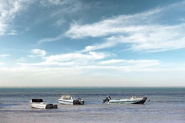 Old metal boats on clear Black sea water. Blue sky with clouds on background