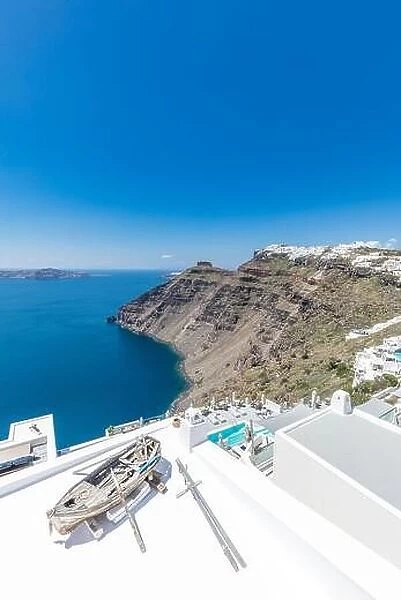 Old wooden boat on the white rooftops of caldera in Santorini, Greece. Amazing summer landscape, travel adventure, sea view over white architecture