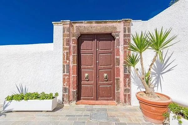 Old wooden door with white architecture in Santorini Greece. Sunny summer weather, vacation, Europe traveling destination, relax, background