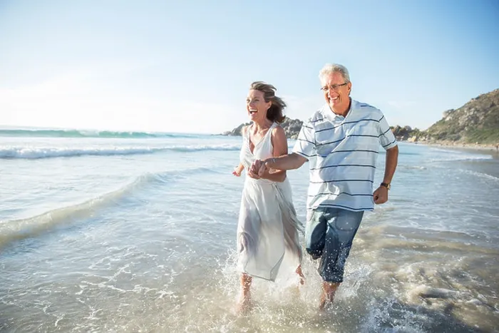 Framed Print : Older couple playing in waves on beach Framed Print : Older couple playing in waves on beach