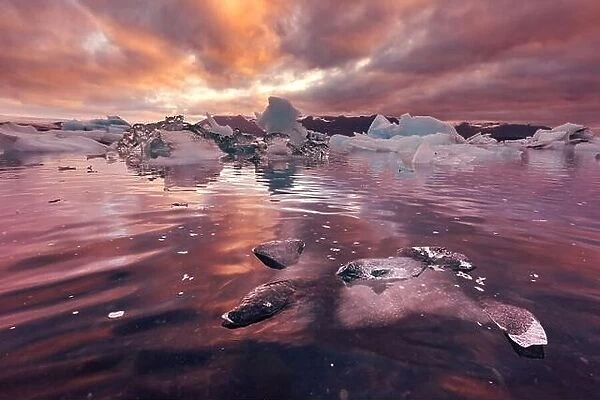Orange sunset and icebergs in Jokulsarlon glacial lagoon. Vatnajokull National Park, southeast Iceland, Europe. Landscape photography