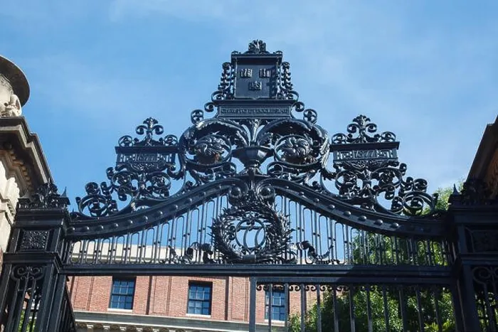 Framed Print : An Ornate iron gate and the historical brick buildings of Harvard University in Cambridge Framed Print : An Ornate iron gate and the historical brick buildings of Harvard University in Cambridge
