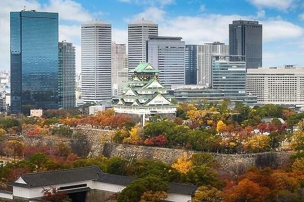 Osaka Castle with Japanese garden and city office building skyscraper at autumn season in Osaka, Japan. Japan tourism, history building, or tradition