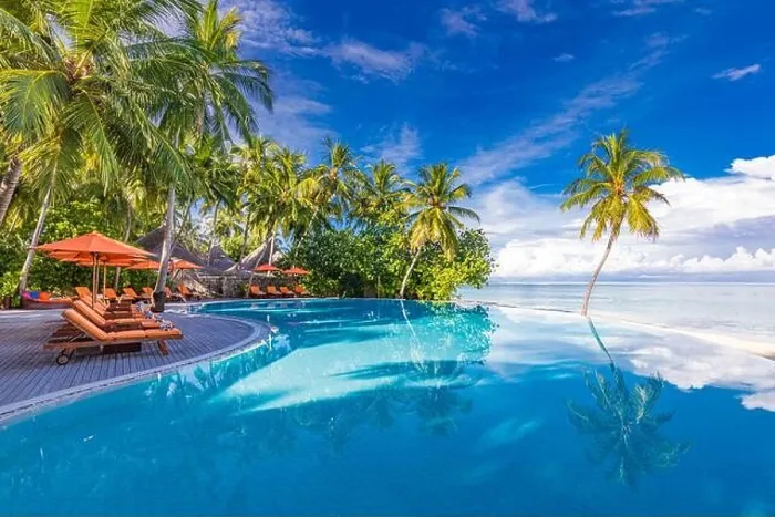 Framed Print : Outdoor tourism landscape. Luxurious beach resort with swimming pool and beach chairs or loungers under umbrellas with palm trees and blue sky. Summer Framed Print : Outdoor tourism landscape. Luxurious beach resort with swimming pool and beach chairs or loungers under umbrellas with palm trees and blue sky. Summer